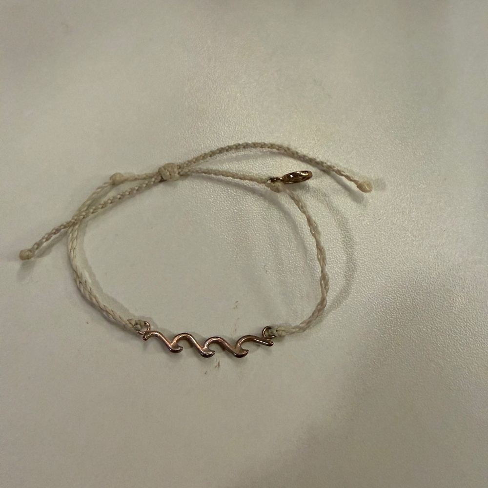 Cream Pura Vida bracelet with rose gold wave charm